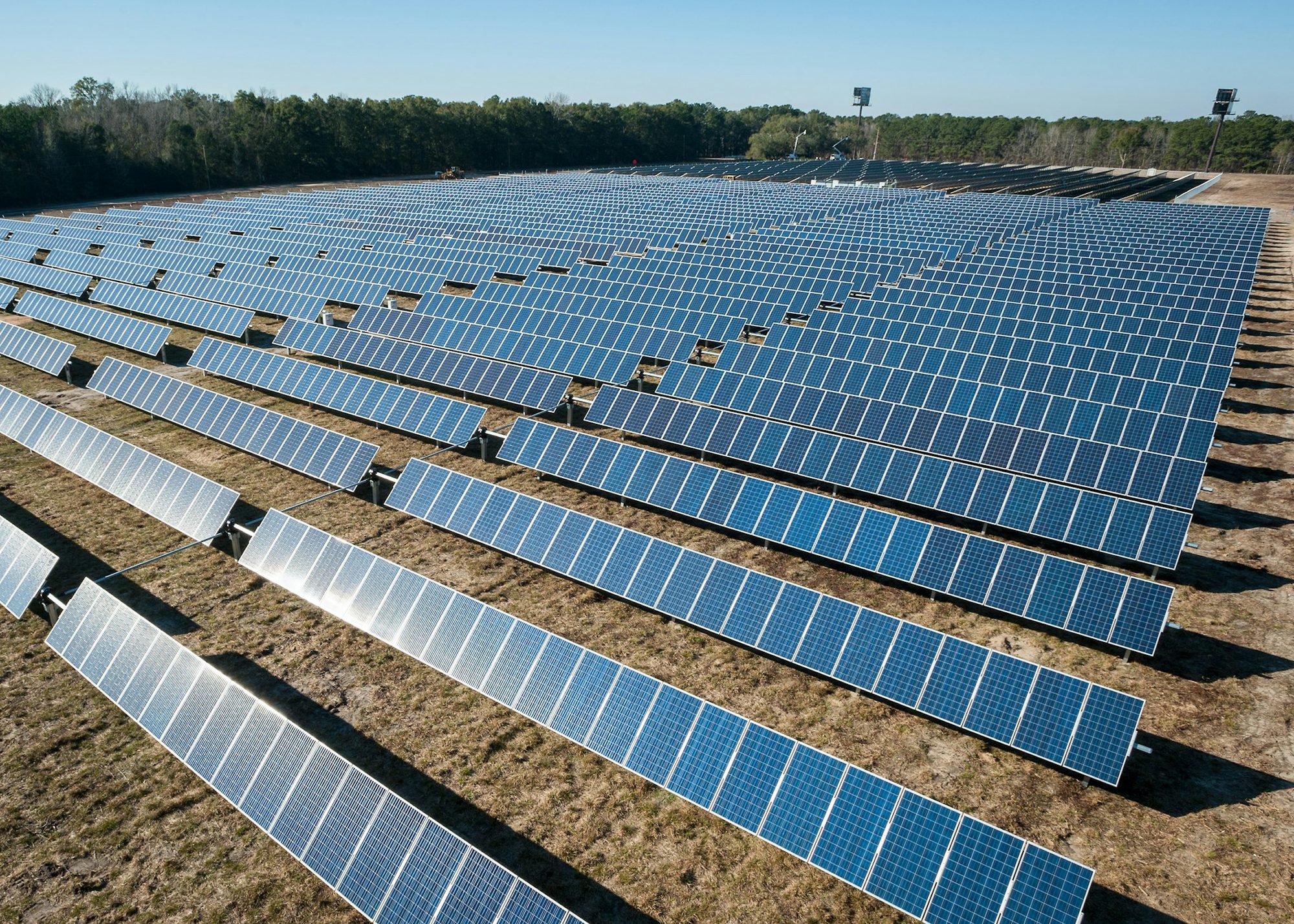 Rows of solar photovoltaic panels on open arid ground