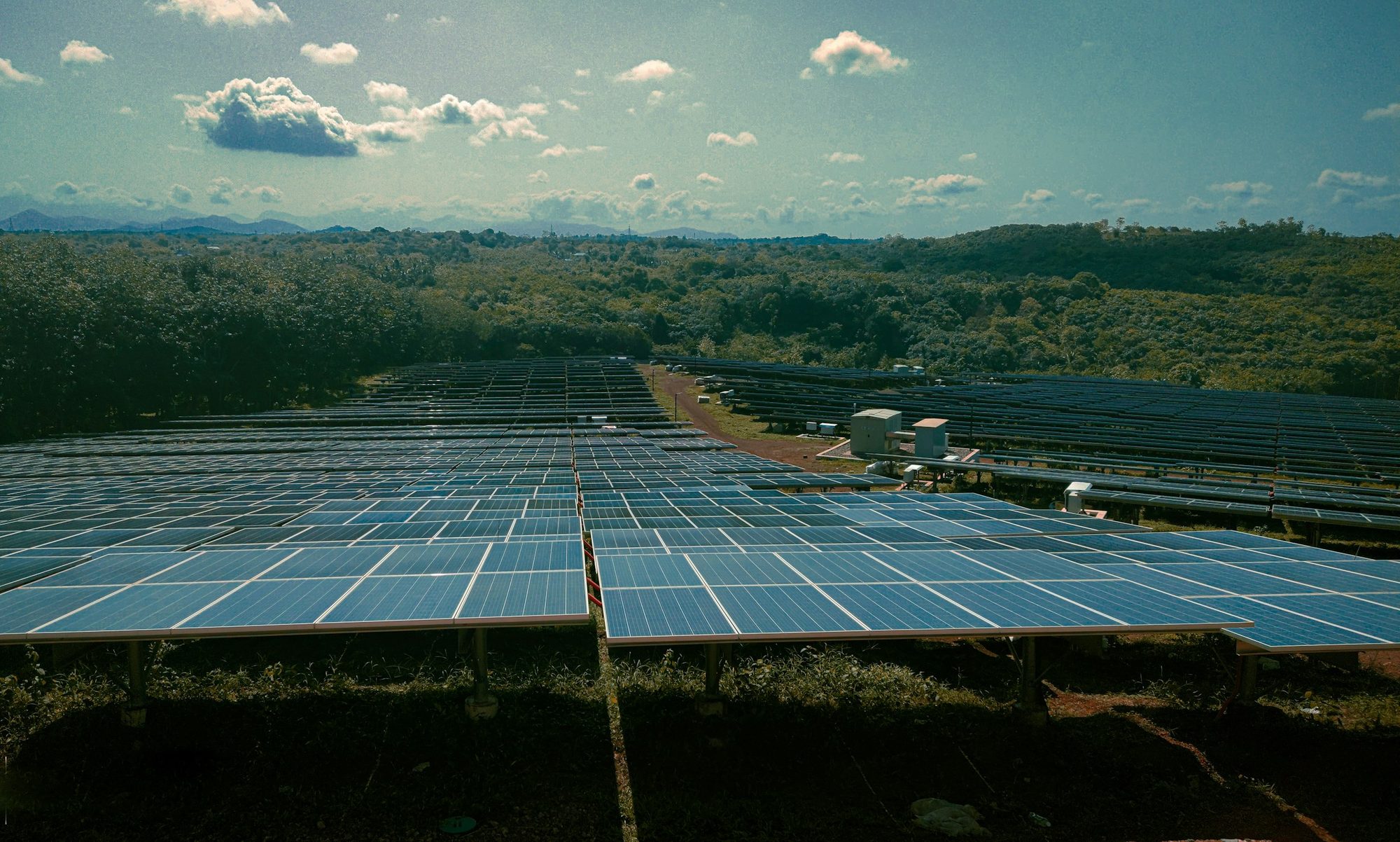 A utility-scale solar farm seen across many rows of panels