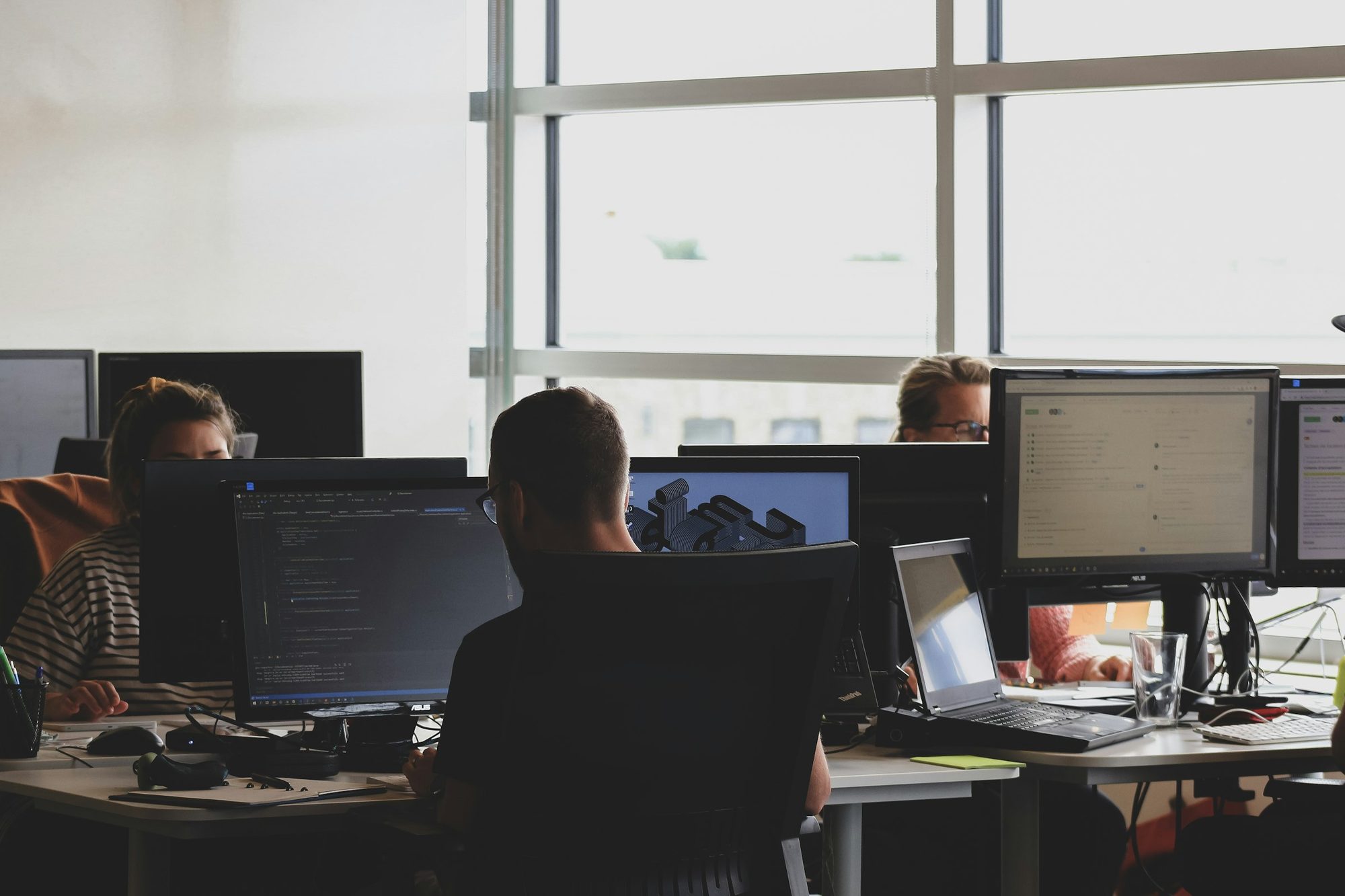 A bright, modern operations room with staff working across multiple screens